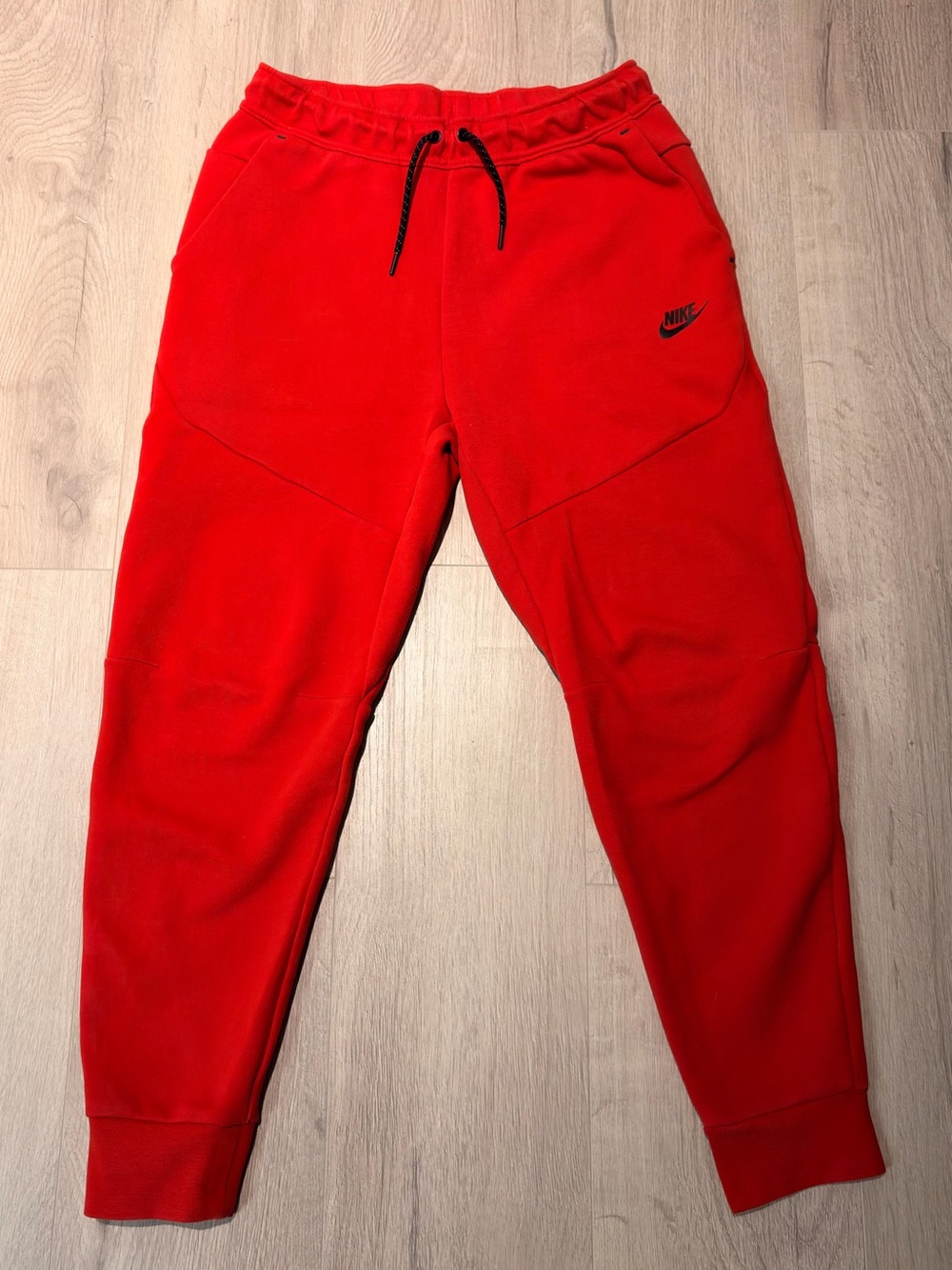 Red Nike tech pants